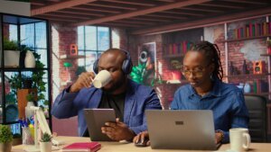 black woman is working while her partner listens music her
