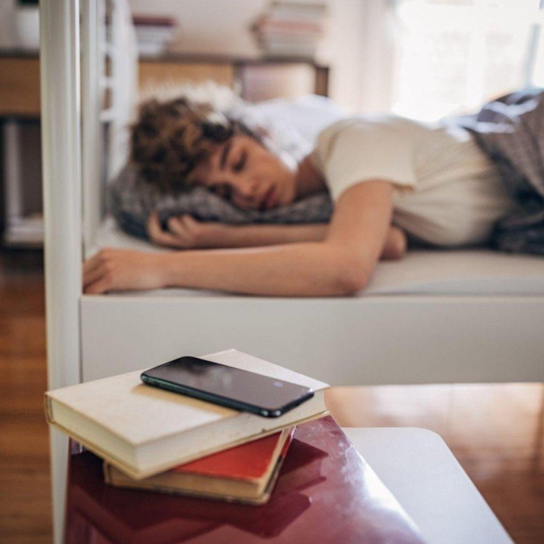 How to Reduce Screen Time: 10 Simple Ways to Improve Daily Life 3 Phone placed away from bed before bedtime